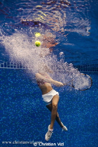 Samantha playing tenis underwater. by Christian Vizl 